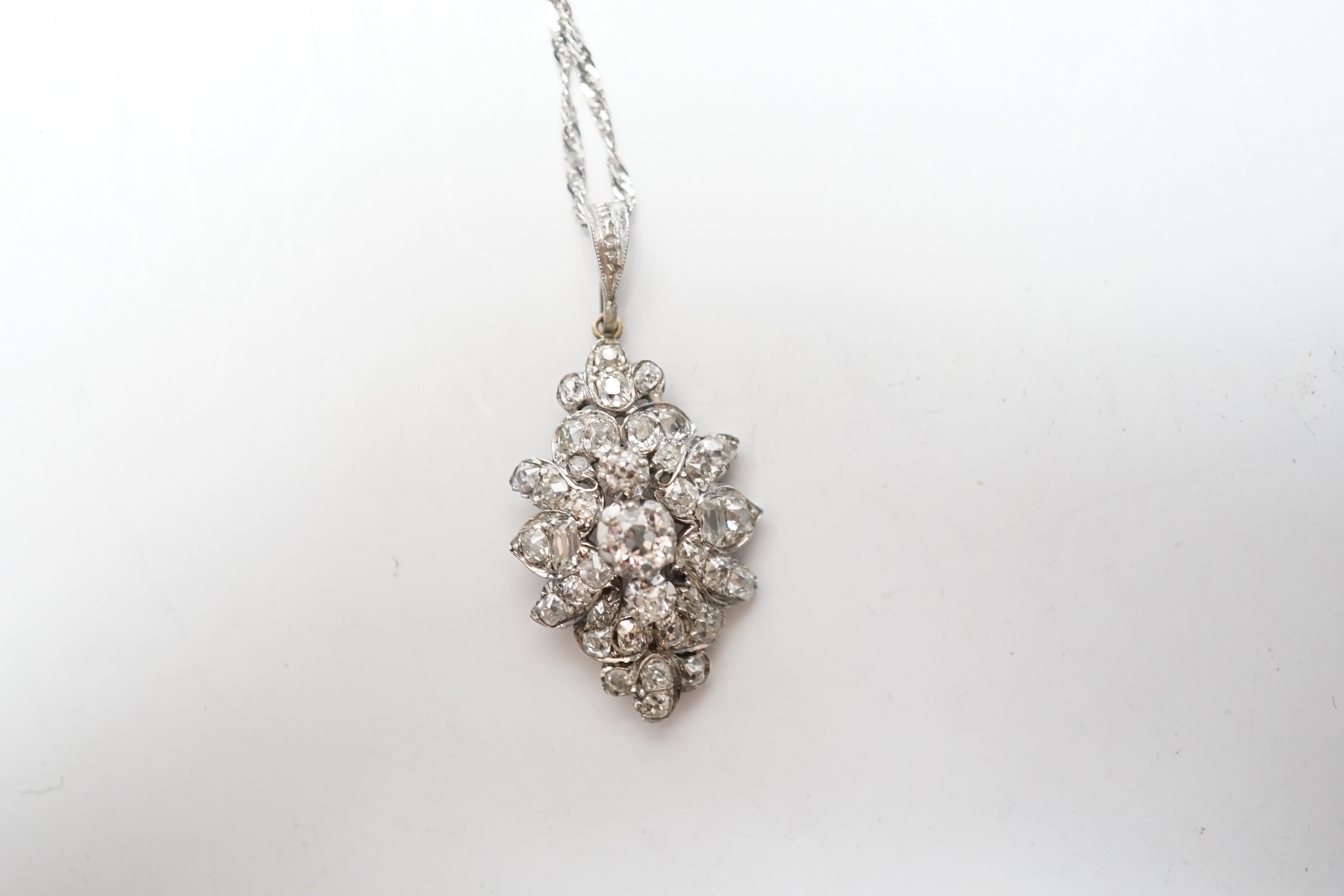A white metal and diamond cluster set lozenge shape pendant, overall 38mm, on a modern 9ct white gold, chain, 45cm, gross weight 5.8 grams.